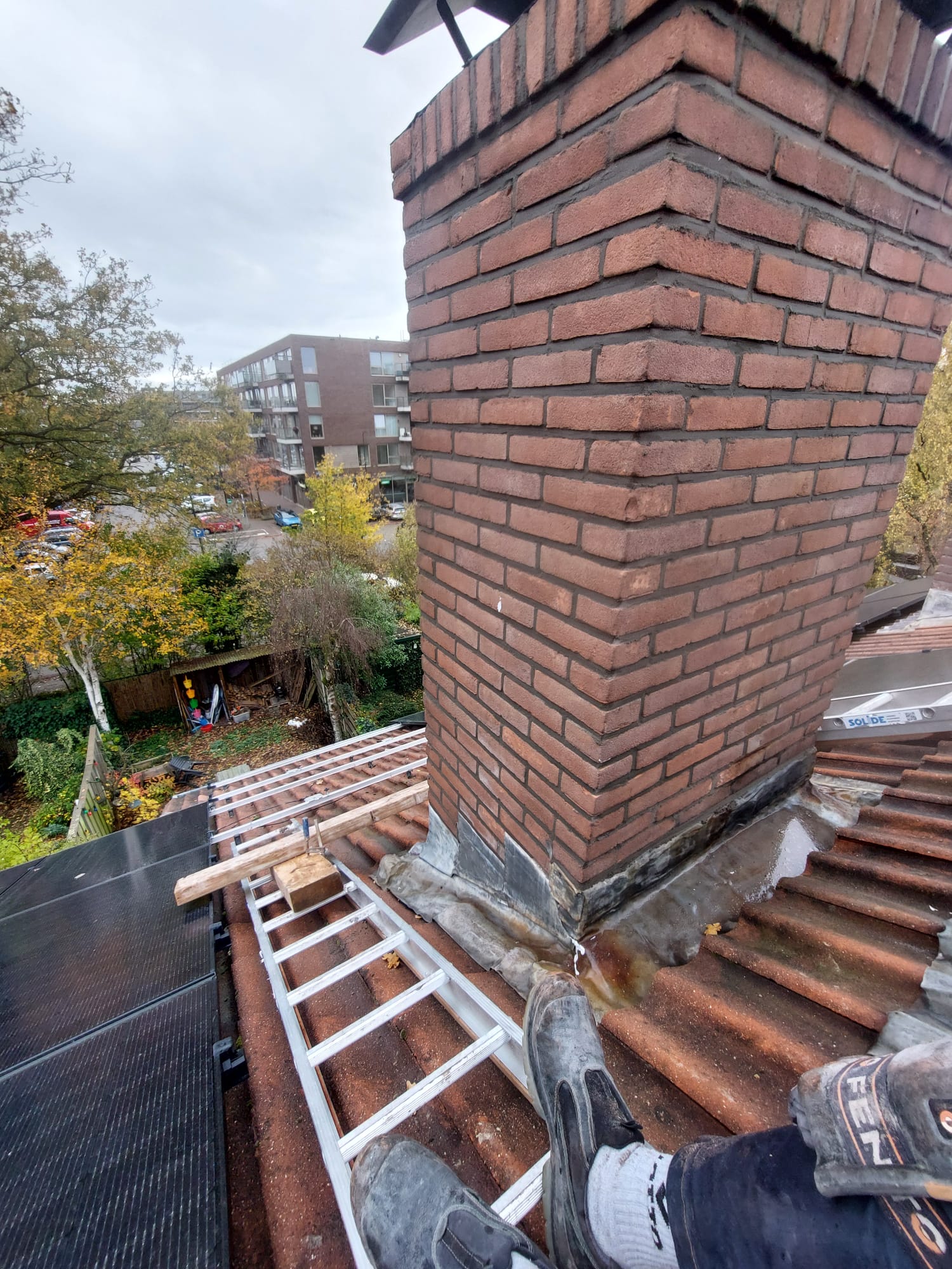 Gemetselde schoorsteen op een pannendak met nieuw loodwerk