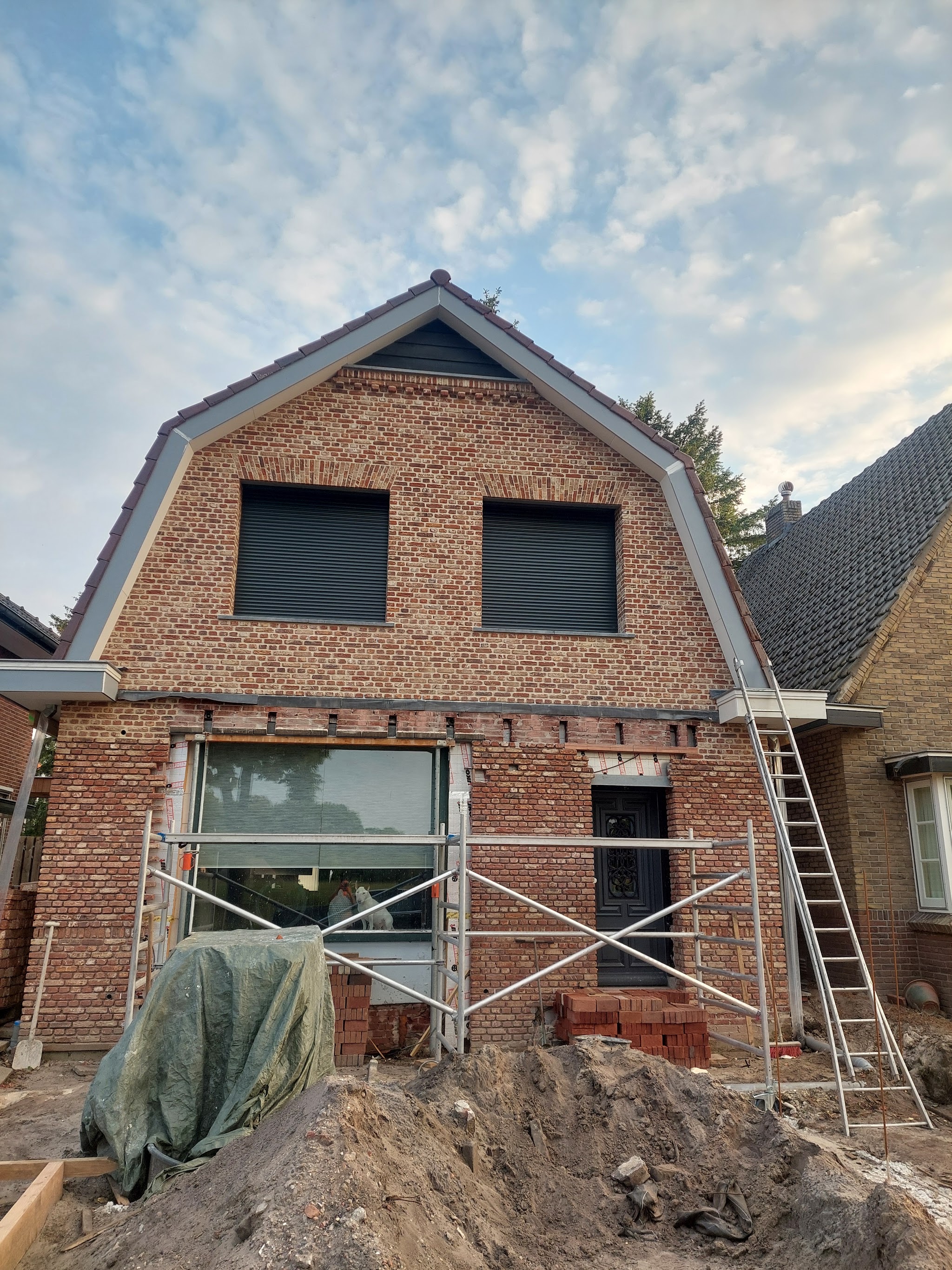 Woning met nieuwe gemetselde voorgevel in de steigers