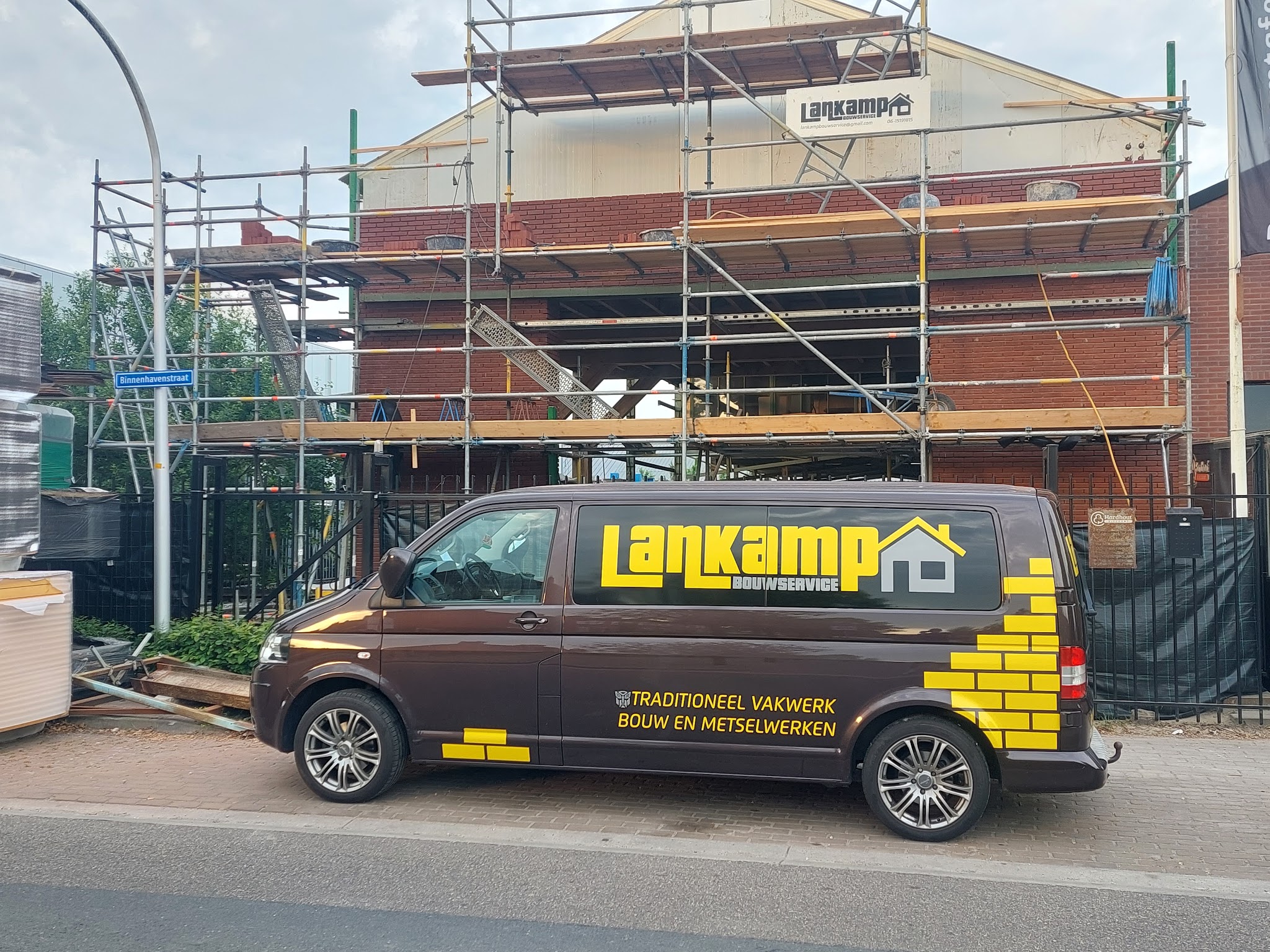 De bus van Lankamp Bouwservice voor een nieuwbouwwoning in de steigers