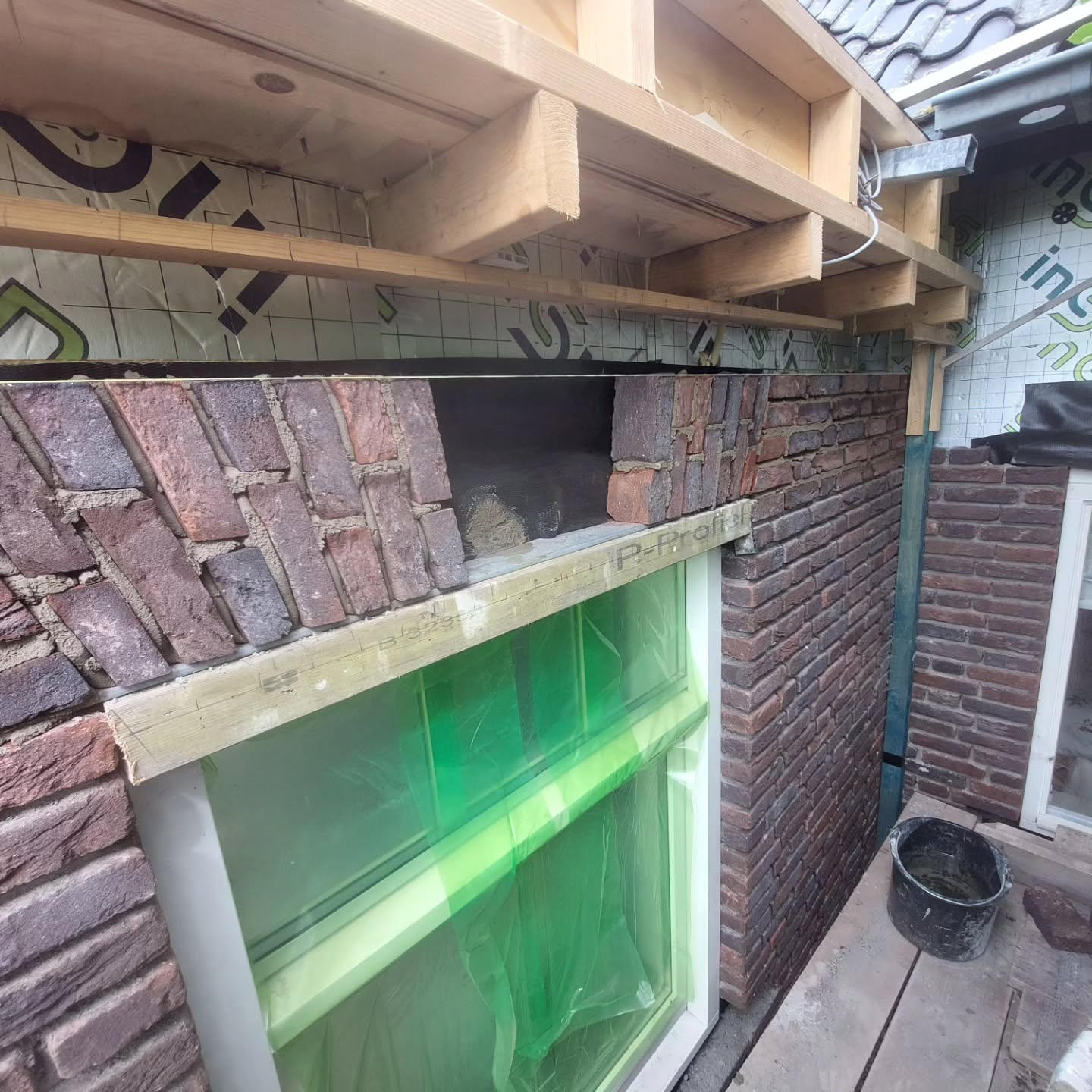 Nieuw metselwerk boven een kozijn, nog in de folie